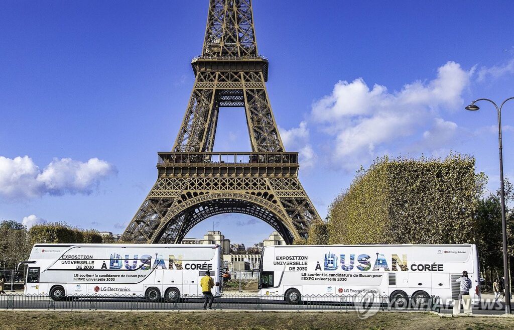 Des autocars arborant des messages promotionnels en faveur de la candidature sud-coréenne pour l'organisation de l'Exposition universelle de 2030 à Busan, ville portuaire du sud-est du pays, passent devant la tour Eiffel à Paris, dans cette photo fournie par LG Electronics.